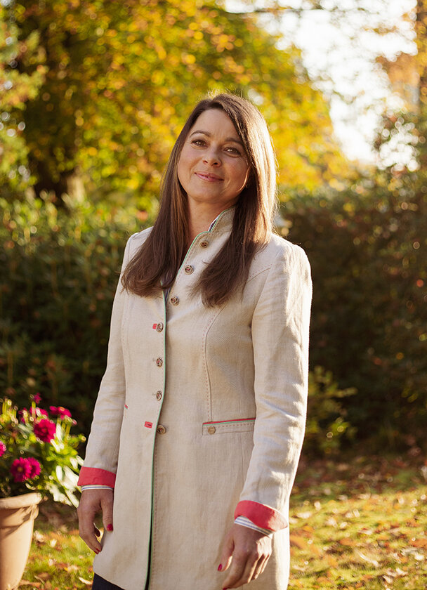 Frau mit langen, braunen Haaren stehend in der Natur