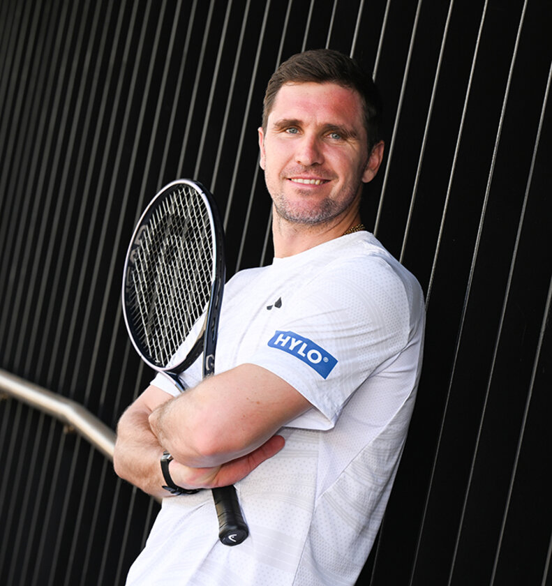 Profisportler mit Tennisschläger im Arm