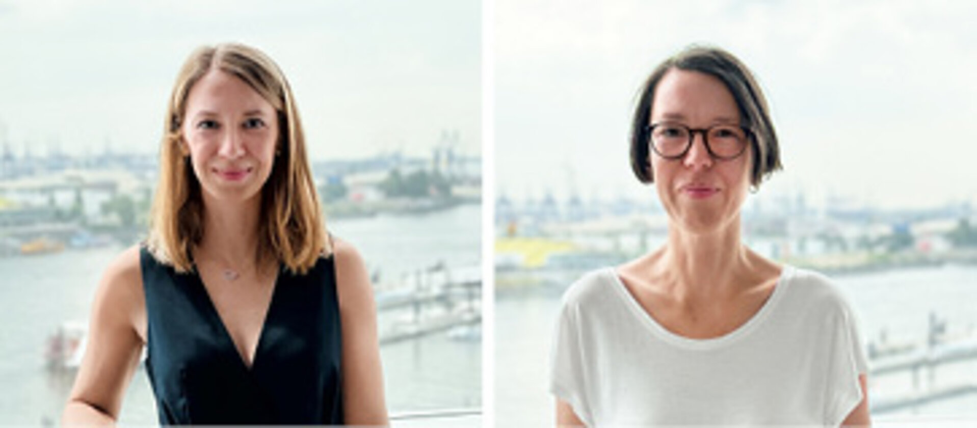 Zwei Frauen gucken beide freundlich frontal in die Kamera. Die auf der linken Seite hat rote, schulterlange Haare und trägt ein schwarzes Sommerkleid, die auf der rechten Seite hat ein weißes T-Shirt an und ein, trägt einen braunen Bob und eine braune Hornbrille.